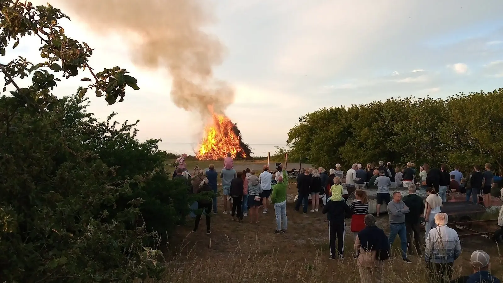 Sankt-Hans-Feuer an der Küste von Bornholm, Zuschauer im Abendlicht